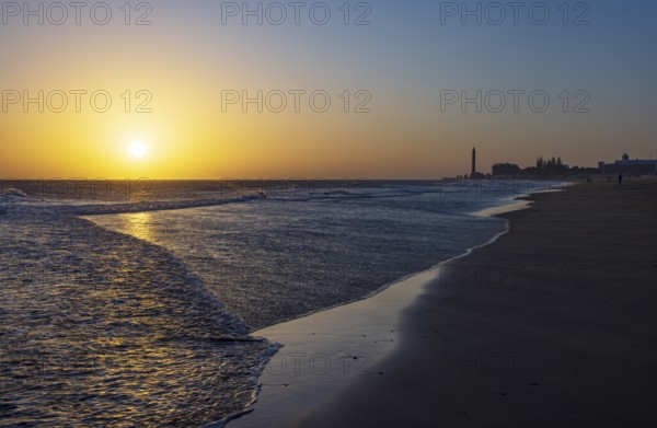 Sunset at the beach of Maspalomas with lighthouse Faro de Maspalomas, Gran Canaria, Canary Islands,