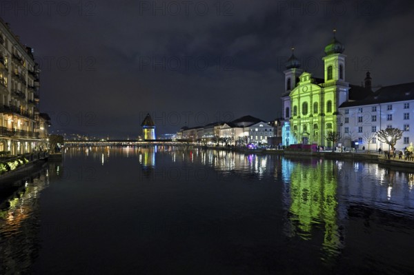Water tower and Jesuit church on the right with light installation, on the Reuss at dusk, Old Town,