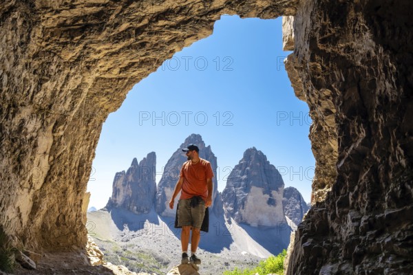 Hiker enjoying the scenic view of tre cime di lavaredo, a symbol of the dolomites, from inside a