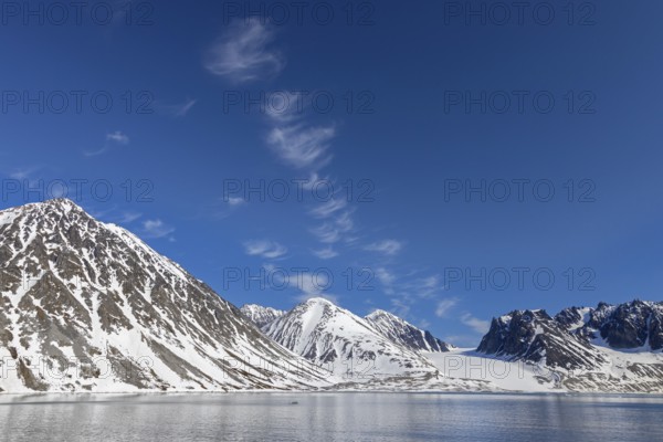 Cirrus uncinus clouds above mountain with glacier along Magdalenefjorden, fjord in Albert I Land on