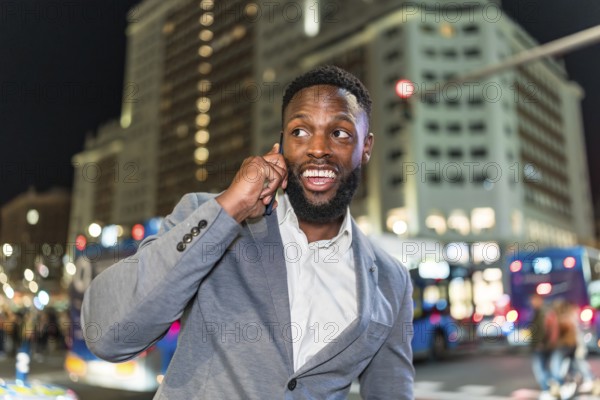 Young businessman engaging in a phone conversation while navigating the bustling city center at