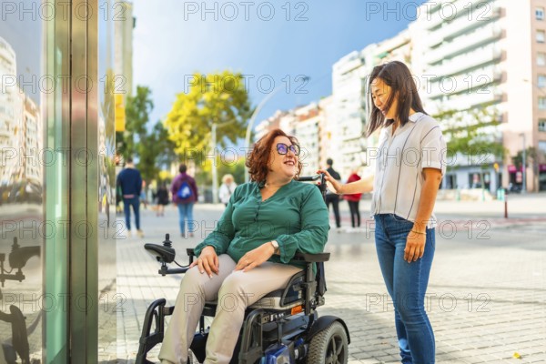 Disabled woman in wheelchair and chinese caregiver waiting at metro elevator in the city during