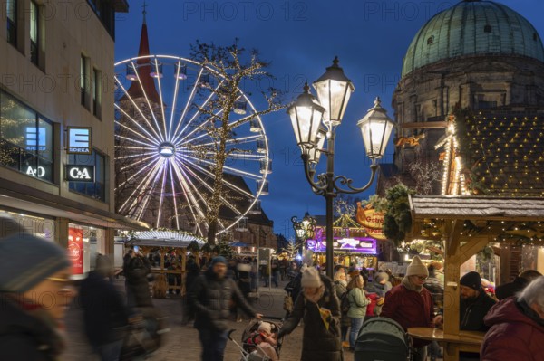 Ferris wheel at the winter village, Christmas market at dusk, St James' Church on the left, St