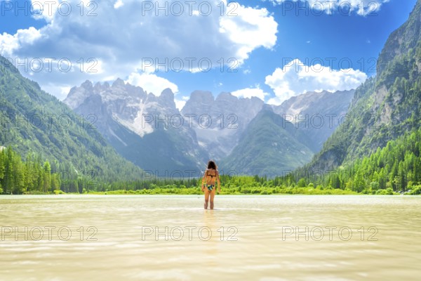 Woman wearing bikini enjoying a refreshing swim in the crystal clear waters of lago di landro,