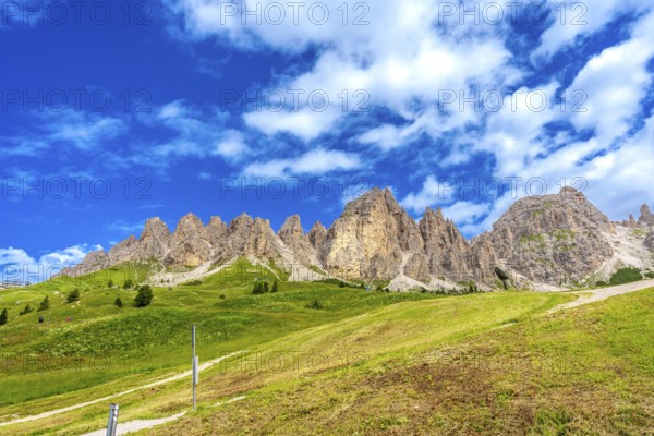 Green meadows and imposing peaks of the dolomites illuminated by the summer sun, creating a
