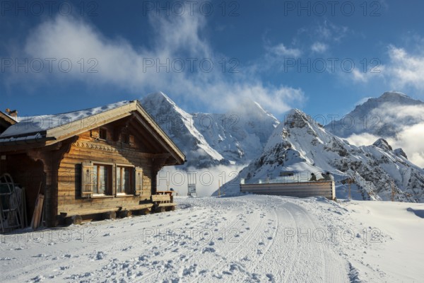 Wooden chalet and ski slope, with views of the Eiger, Mönch and Tschuggen, Grindelwald, Bernese