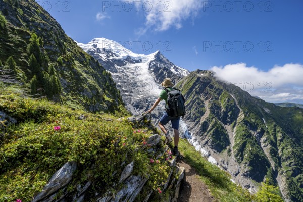 Hiker on hiking trail La Jonction, mountain landscape, view of glacier Glacier de Taconnaz,