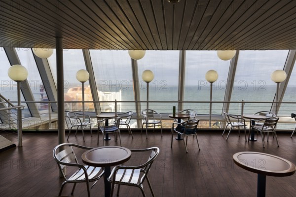 Empty tables and chairs, deck of a ferry to Wales with a view of the sea, interior shot, Rosslare,