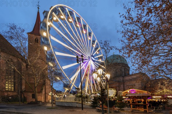 Ferris wheel at the winter village, Christmas market at dusk, St James' Church on the left, St