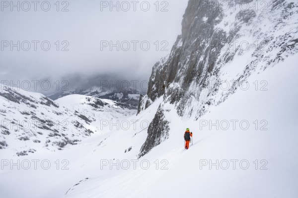 Ski tourer on a steep mountain slope, Snowy mountain landscape, Bernese Alps, Bernese Oberland,