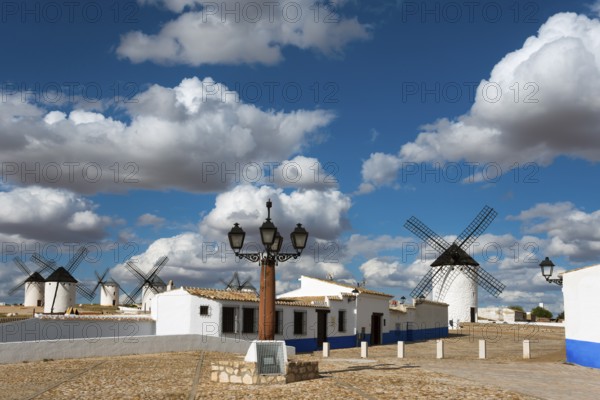 Windmills and street lamp in a charming village under a blue sky with clouds, windmills and