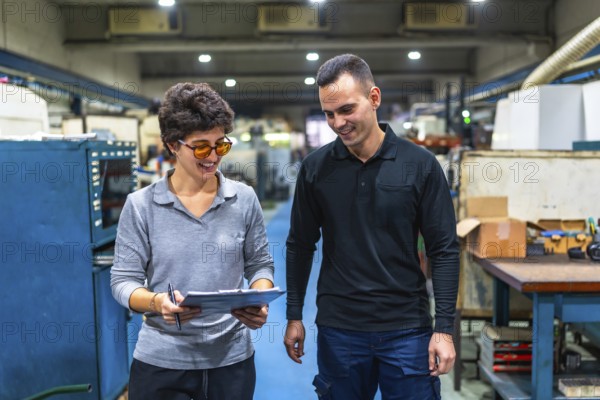 Woman manager and male worker walking checking stock inventory with clipboard and discuss talking