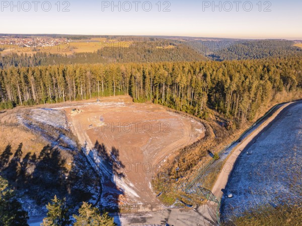 View of deforested land and neighbouring forests under a clear sky, landfill. Neubulach, Black