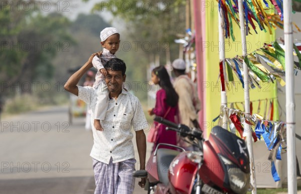 KAYAKUCHI, INDIA - MARCH 31: Muslim man with his children arrives to perform Eid al-Fitr prayer at
