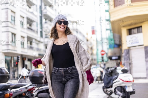 Lifestyle, young Caucasian blonde girl enjoying and smiling in the city in winter. Strolling with