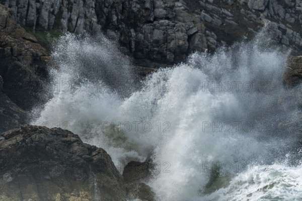 Large waves of the Atlantic Ocean crash against the rocks of a cliff. Camaret sur mer, Crozon,