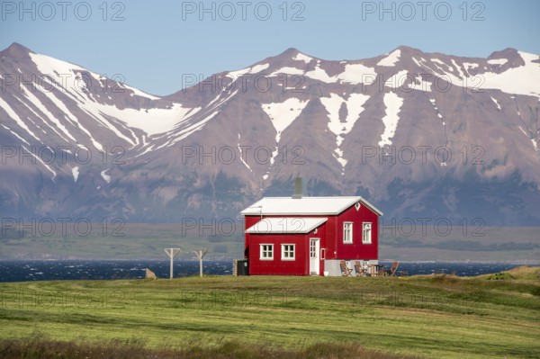 Red house near Dalvik or Dalvik, mountains with snow remains, Eyjafjörður or Eyjarfjörður or