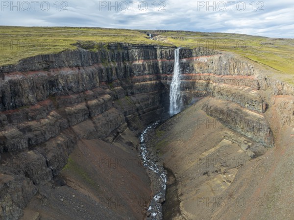 Waterfall Hengifoss, basaltic layers interwoven with red sedimentary layers, aerial view, Iceland,