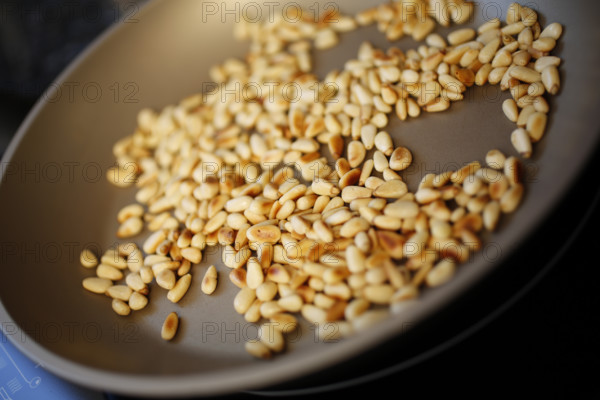 Swabian cuisine, preparation of beef roulade with pine nuts, roasting pine nuts in a pan,