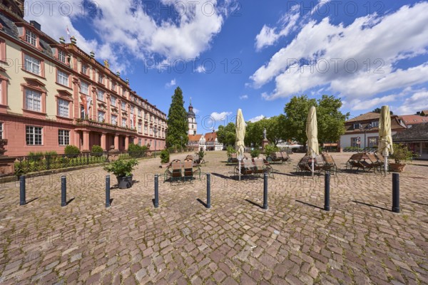 Erbach Castle, outdoor area of a restaurant with tables, chairs and parasol, bollards, trees,