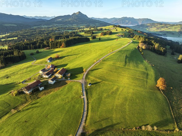Mountain range near village Wertach, view to mt. Gruenten, sunrise, fog in valley, traditional