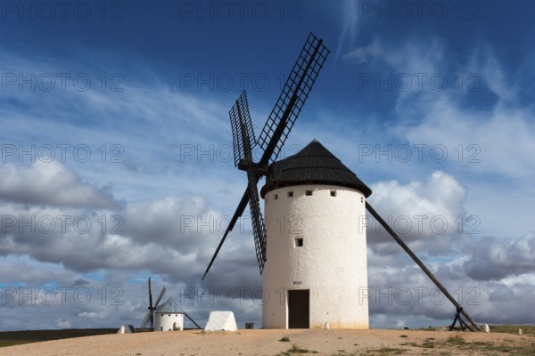 White windmill under a dramatic sky with other mills in the background, Campo de Criptana, Ciudad