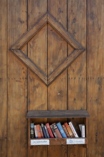 Books to give away on a shelf on a wooden wall, Riegel am Kaiserstuhl, Baden-Württemberg, Germany,
