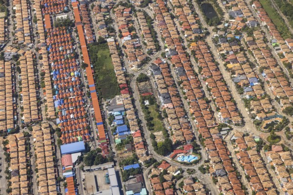 Retort city in the north-east of Bangkok. Standardised houses stand close together on the straight