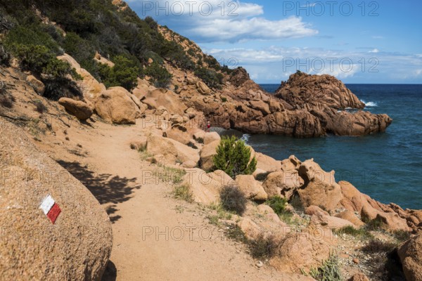 Hiking trail along the coast with red rocks and sea, Spiaggia di Coccorocci, near Tertenia,