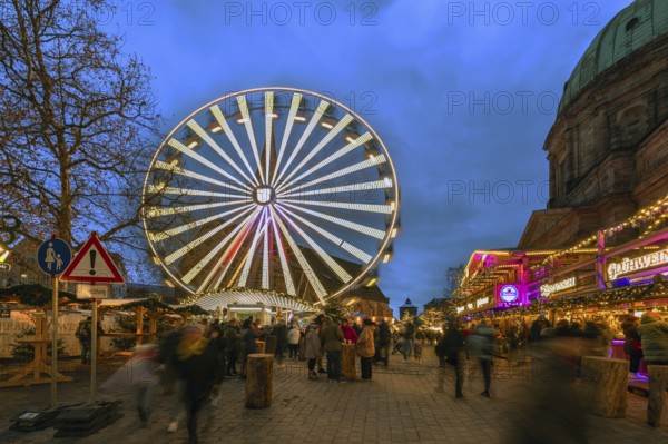 Ferris wheel at the winter village, Christmas market at dusk, St Elisabeth's Church on the right,