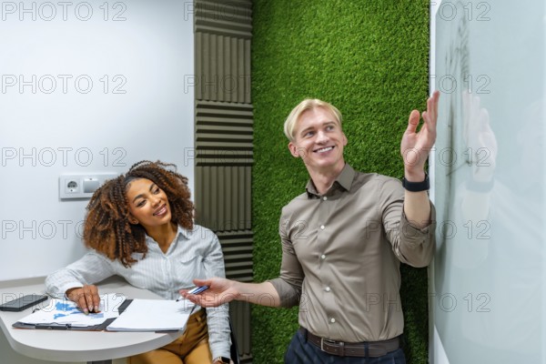 Two managers analyzing data and discussing strategy during a meeting in a modern coworking office
