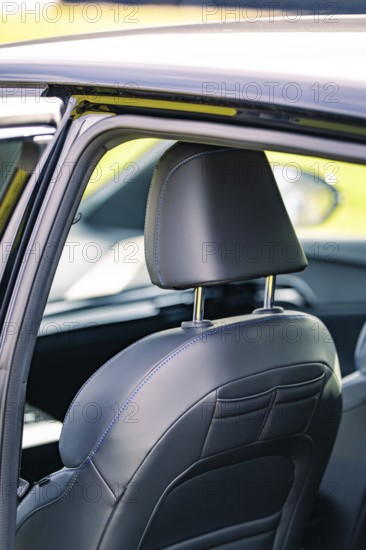 Detailed view of the rear vehicle interior with a leather seat and headrest, e-car sharing, Deer