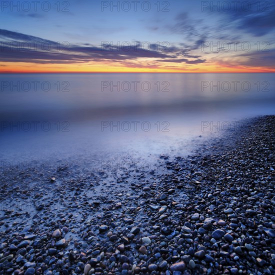 Pebbles in the water on the shore of the Baltic Sea at dusk after sunset, Weststrand Darß,