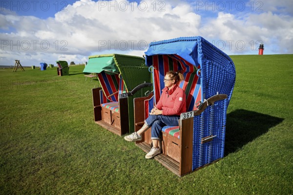 Woman in a beach chair on the island of Pellworm, Wadden Sea National Park, North Frisia, Germany,
