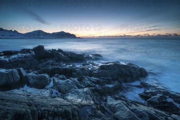 Long exposure after sunset, winter at Skagsanden, rocks washed over by the sea on the beach at
