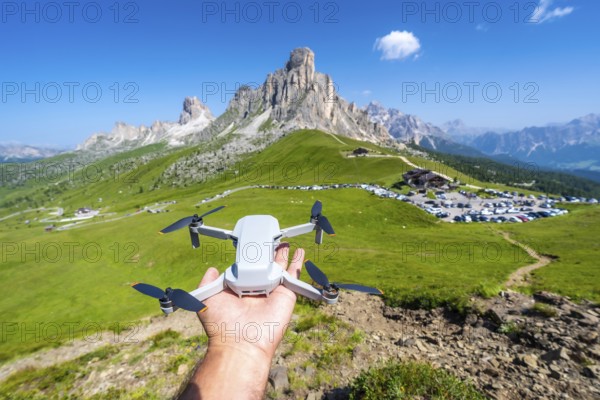 Hand holding a drone ready to fly over passo giau in the italian dolomites, showcasing the