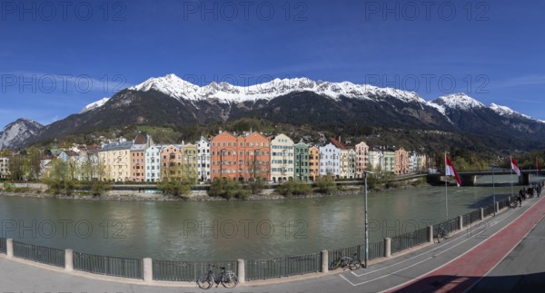 Colourful buildings along the Inn river with snow-covered Nordkette in the background, Karwendel