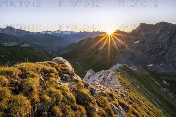 Mountain landscape at sunrise with sun star, view of mountain peaks of the Venediger group and into