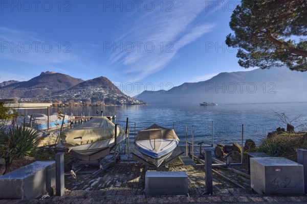 Motorboats, lake, hilly landscape with village, haze, blue sky with cirrostratus clouds, Lake