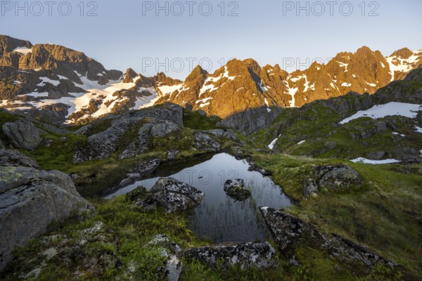 Rocky mountain peaks with reflection, small pond in moor landscape at Trollfjord Hytta, mountain