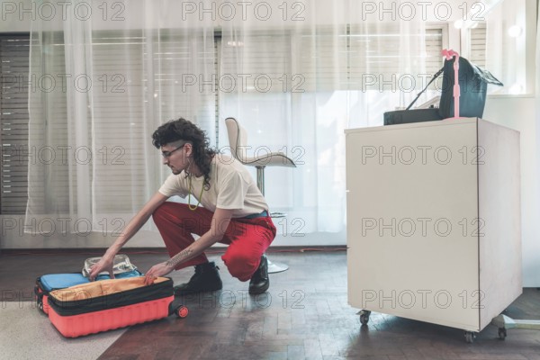 Young non-binary individual with a mullet haircut organizing beauty products in a trolley case,