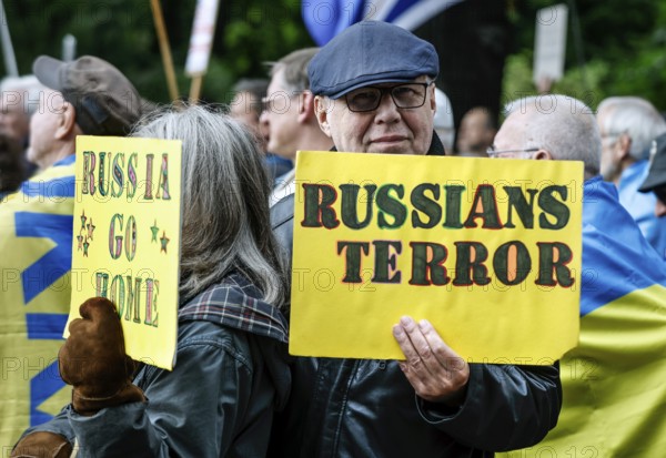 Ukrainians holding placards with the slogan Russia go home at the counter-demonstration Your peace