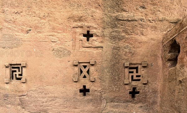 Cross-shaped windows carved in stone in the underground monolithic rock-hewn church of Biete