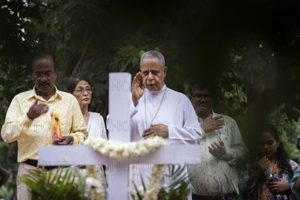 People from Christian community light candles and offer prayers on the grave of their relative