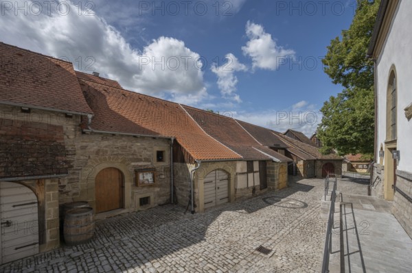 Inner courtyard with former church arcades, barns and St John's Church in the historic fortified