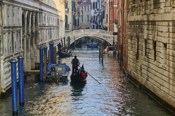 View from 'Ponte della paglia' over a waterway on a sunny morning with gondolier in Venice on a