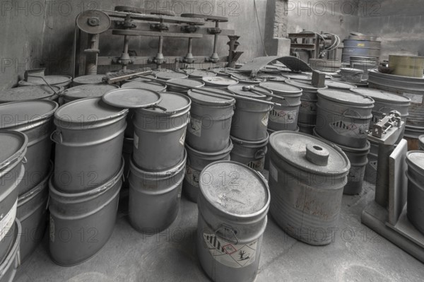 Metal barrels covered with zinc dust in the filling room for zinc powder of a metal powder mill,