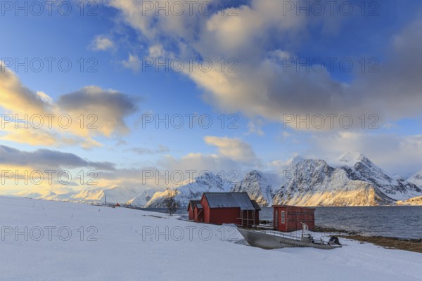 Red boathouses, coast, snowy mountains, fjord, morning light, clouds, snow, Lyngen Alps, Norway,