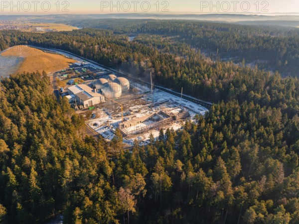 Wide view of a wintry forest area with a construction site and industrial plant, new fire station,