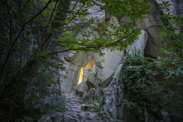 Incidental sun illuminates the passage (Chambre du Roi) through the high rocks, hike through the